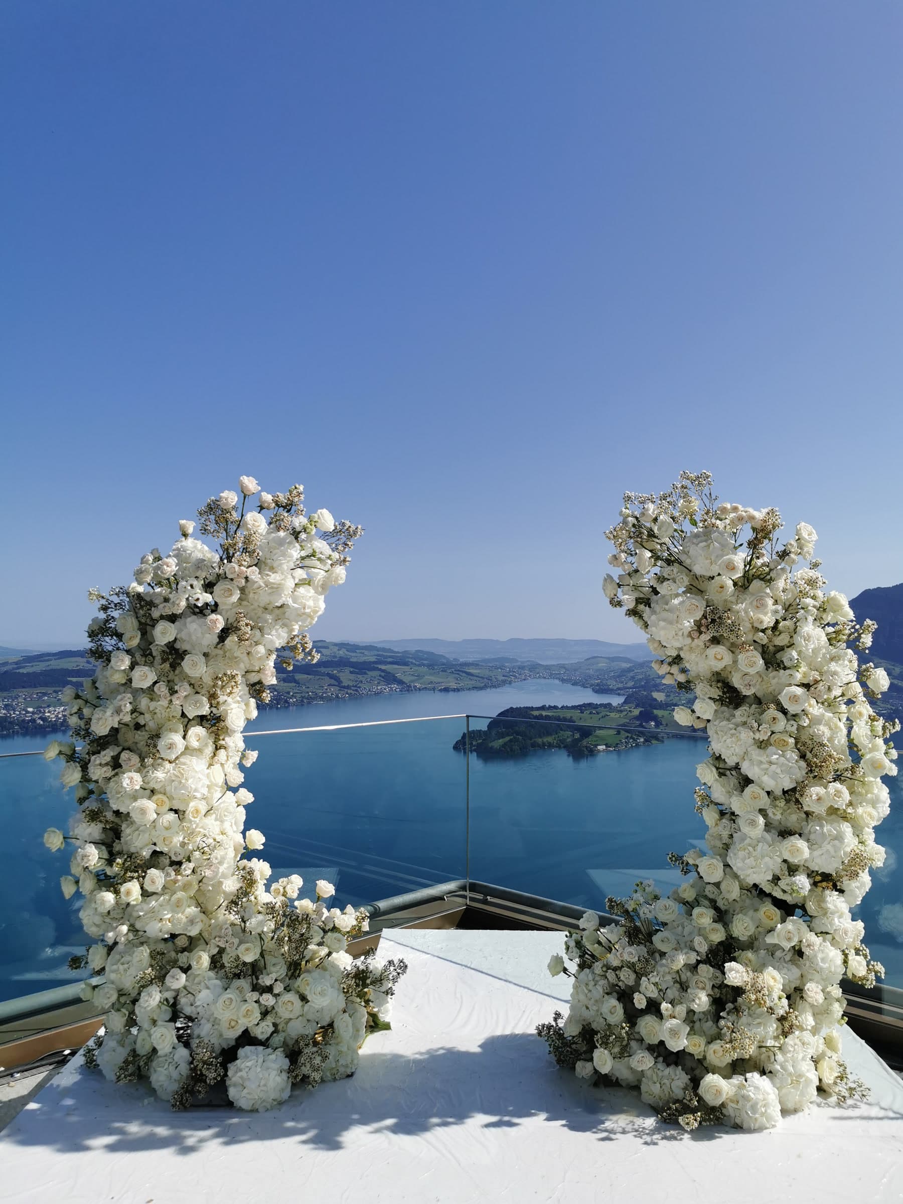 Floraler Hochzeitsbogen aus weissen Rosen mit Panoramablick auf den See